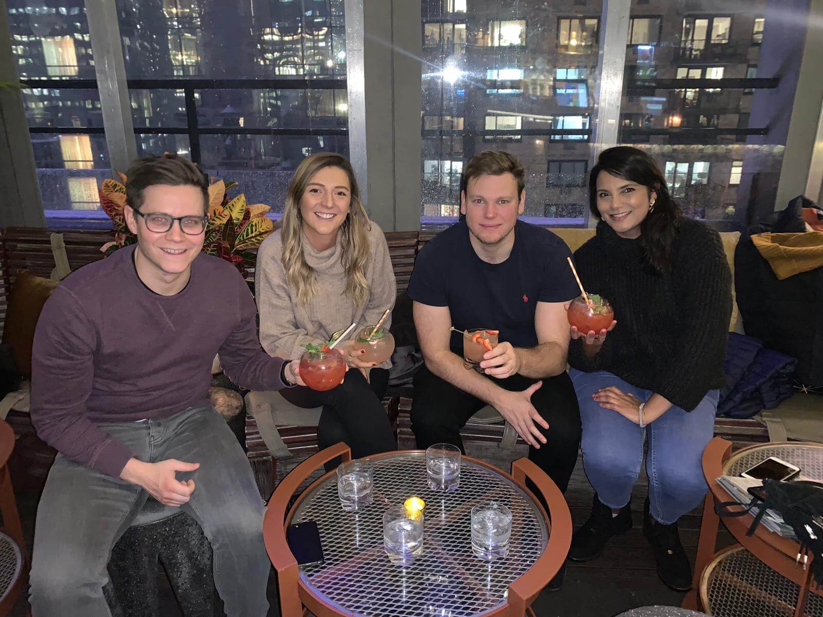 4 people having a drink at a rooftop bar