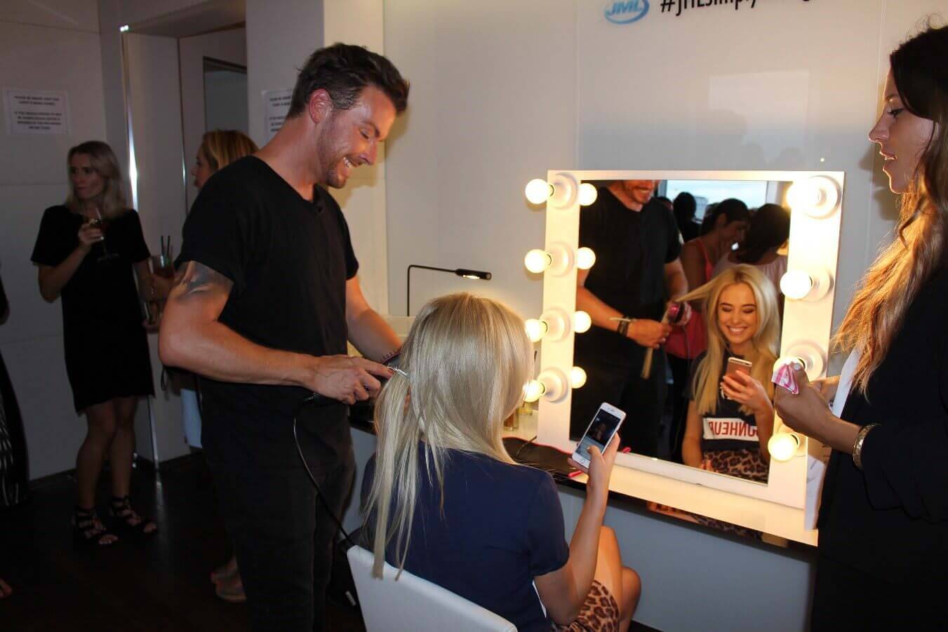 A picture of a male hairdresser doing a girls hair