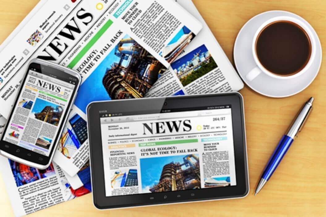 A picture of a newspaper, and ipad and an iPhone and a cup of coffee