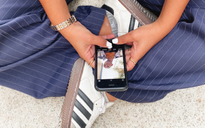 Person sitting down on their phone taking pictures for digital marketing agency - The PHA Group