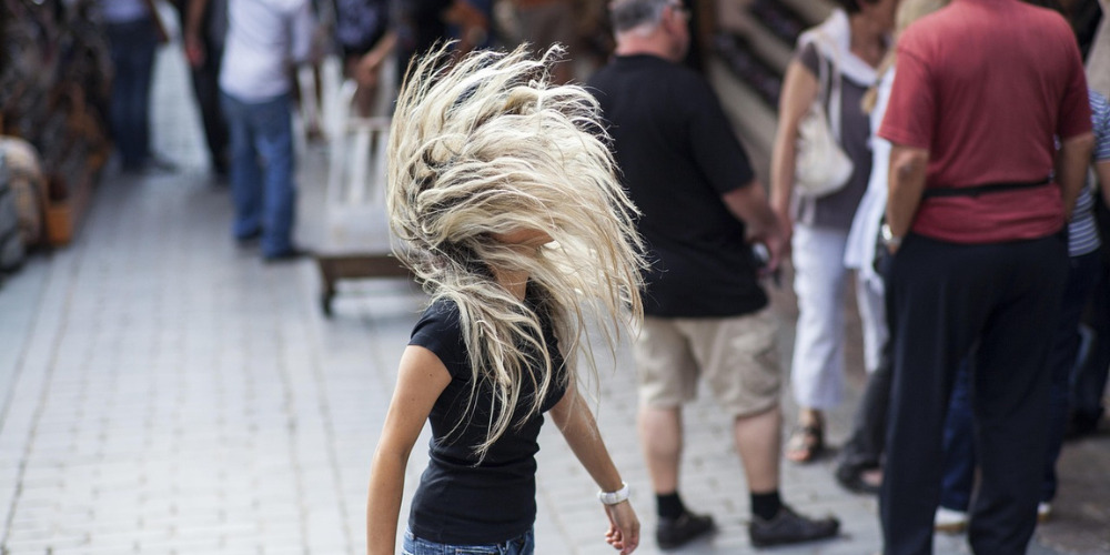 Person flicking their hair standing out from the crowd - The PHA Group