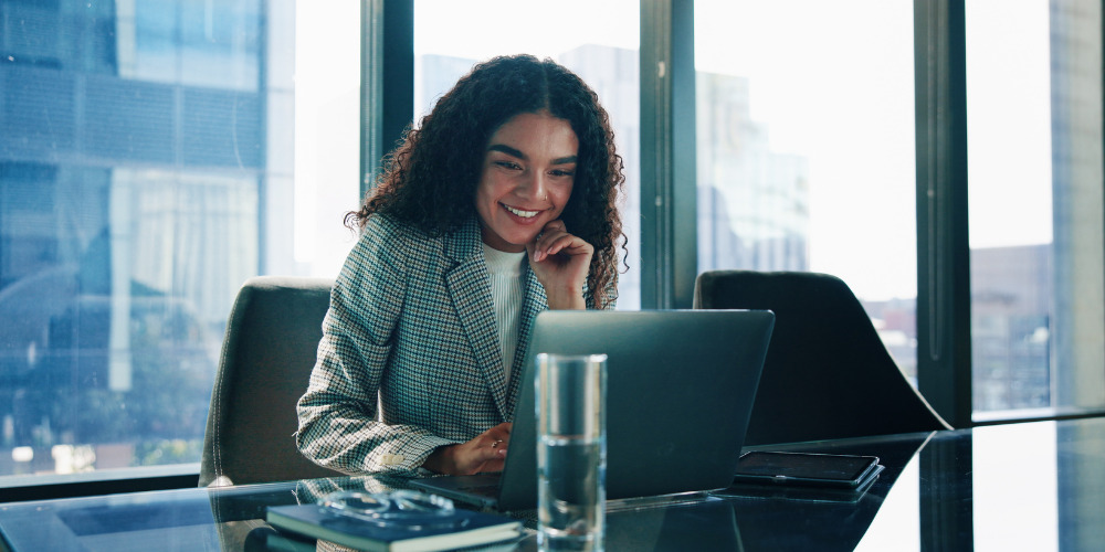 Business woman sat at desk writing a press release optimised for AI visibility - The PHA Group