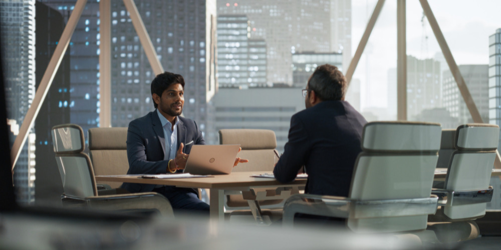 Legal partner and client sitting in high-rise office discussing AI in the legal sector - The PHA Group