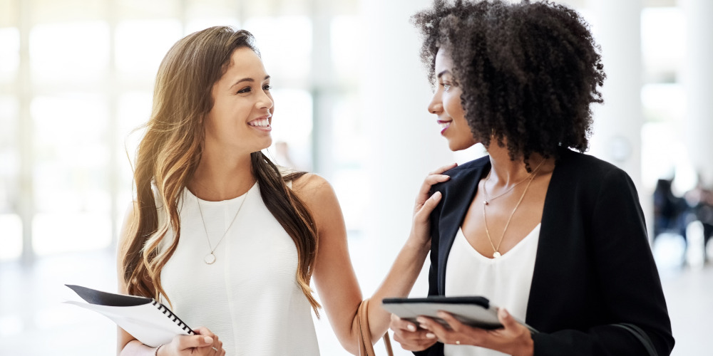 two women discussing the benefits of corporate PR - The PHA Group