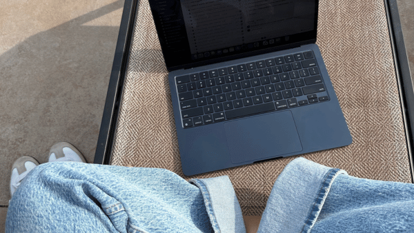 Person sitting on wooden bench with laptop looking for a consumer tech PR agency - The PHA Group
