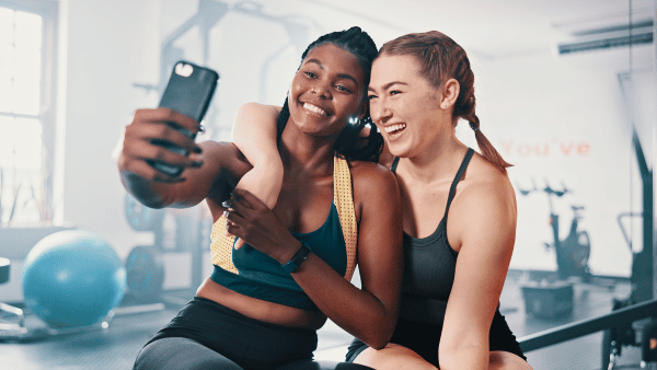 Two woman taking a selfie after their workout - The PHA Group
