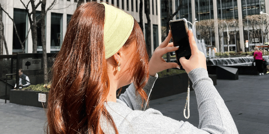Girl on city break taking picture on phone after AI travel discovery chose her destination - The PHA Group