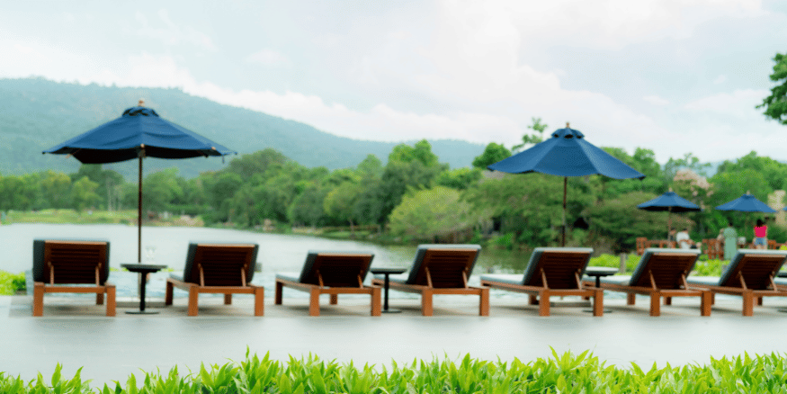 Sunbeds in front of a pool in the mountains of hotel how to avoid greenwashing - The PHA Group